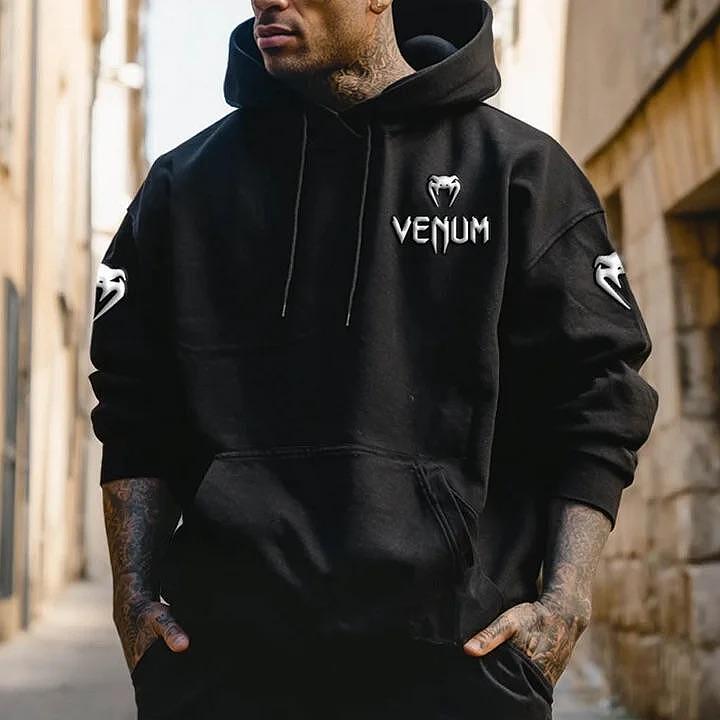 Hanorac negru Venn cu glugă, sigla Venum albă pe piept și simboluri pe mâneci, purtat de bărbat, model casual